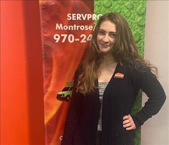 female employee in front of a SERVPRO sign