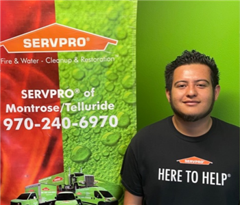 Male employee Edwin, standing in front of a SERVPRO banner